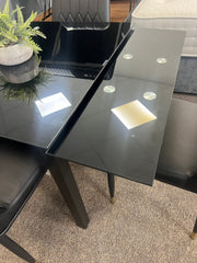 Glass extendable dining table with four chairs